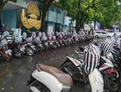 Rapi dan Aman, Jukir yang Satu Ini Bungkus Helm Pelanggan Saat Hujan